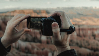 Camcorder wird von zwei Händen gehalten und filmt über eine Schlucht.