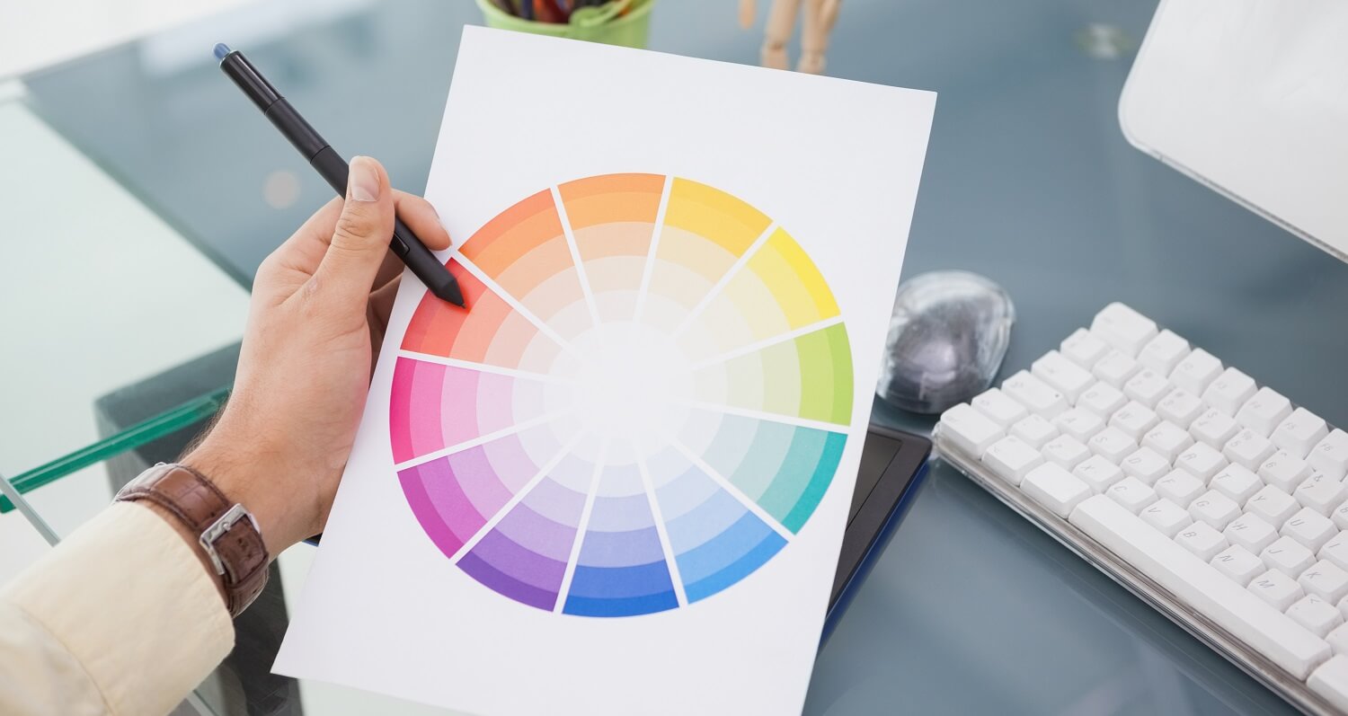 Eine Coloristin hält einen Zettel mit einem Farbrad, um die richtige Farbe für die Filmszene auswählen.