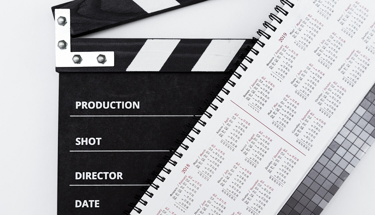 Das Bild zeigt mit einer Filmklappe und einem Kalender wichtige Informationen, die ein Drehplan enthalten muss.