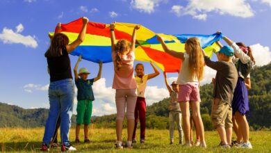 Kinder spielen in einem Kinderfilm mit einem bunten Schwungtuch.