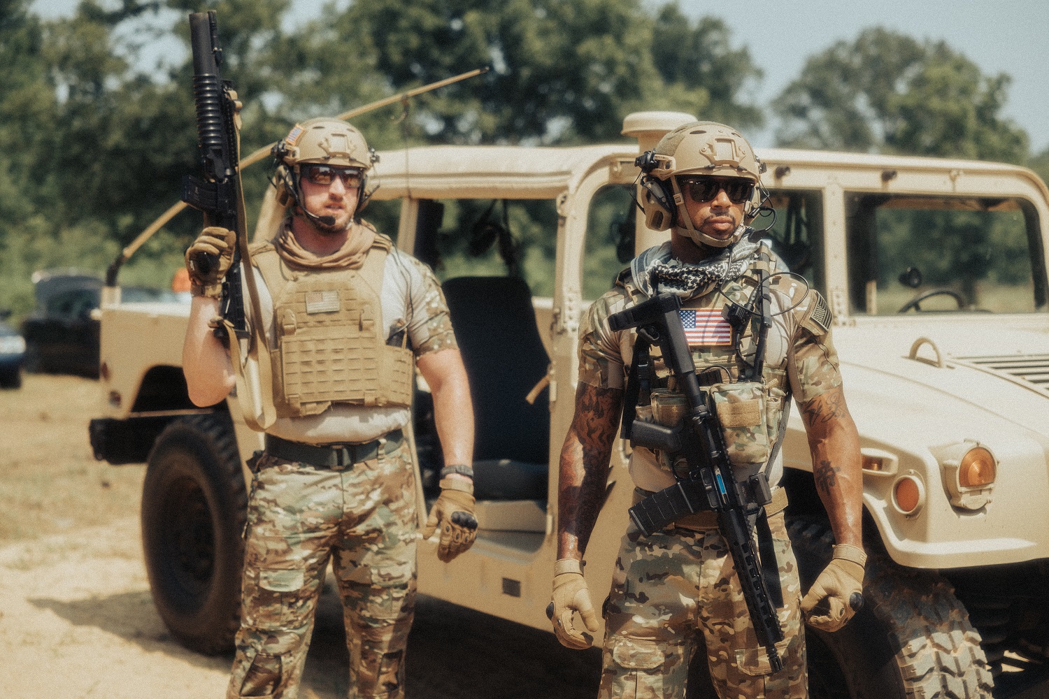 Eine Szene aus einem Kriegsfilm zeigt zwei bewaffnete Soldaten, die vor einem Geländewagen stehen.