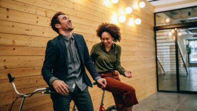 Ein Mann und eine Frau sitzen auf einem Tandem und lachen.