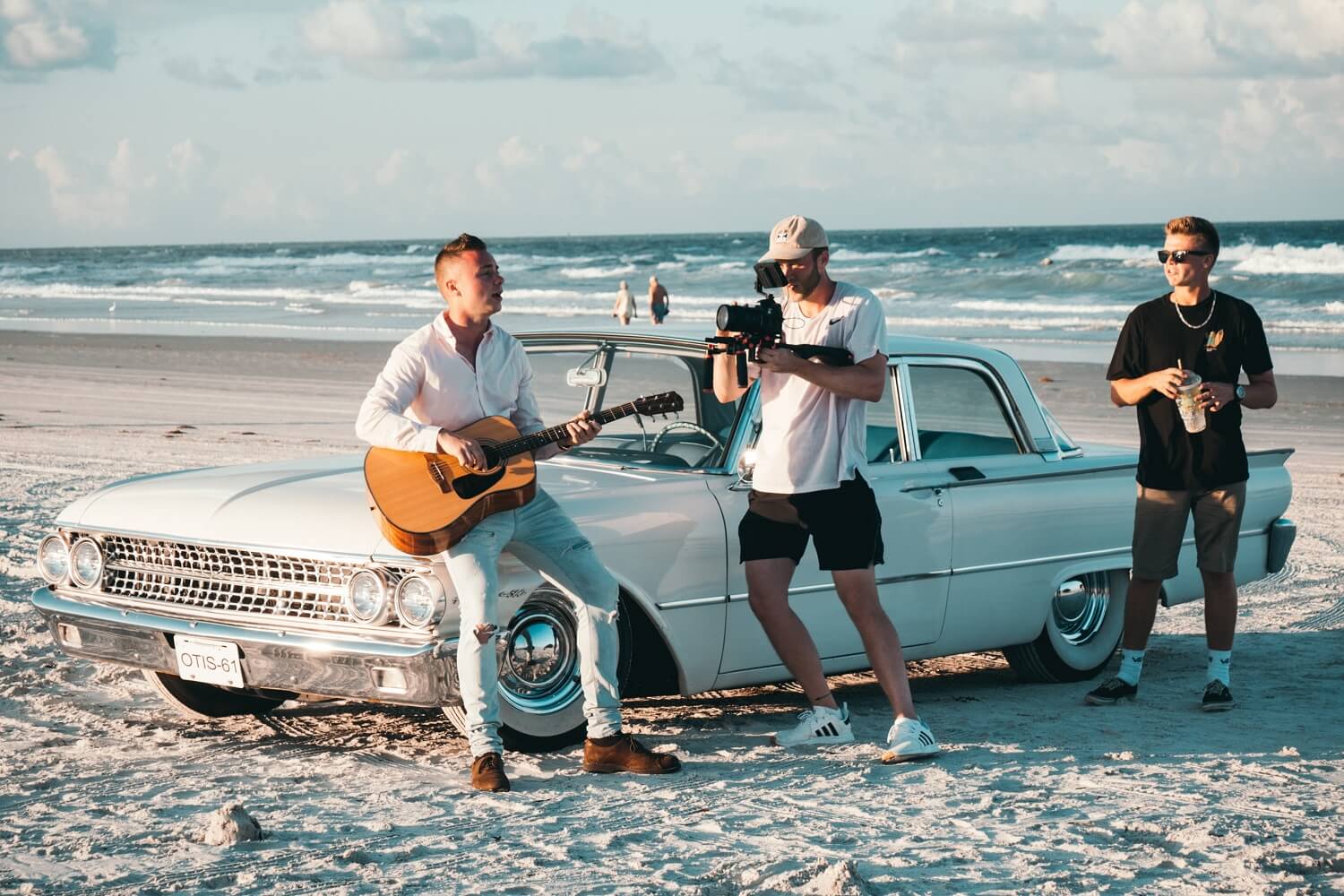 Ein Sänger mit einer Gitarre sitzt in einem Musikvideo, das ebenfalls zu den Kurzfilmen zählt, auf einer Autohaube.