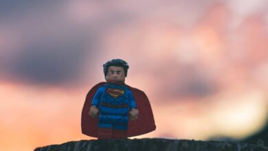 Eine Superman-Legofigur vor einem unscharfen Sonnenuntergang.