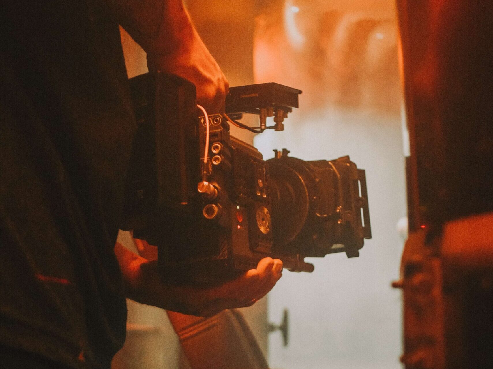 Ein Kameramann hält eine Videokamera an einem Drehort