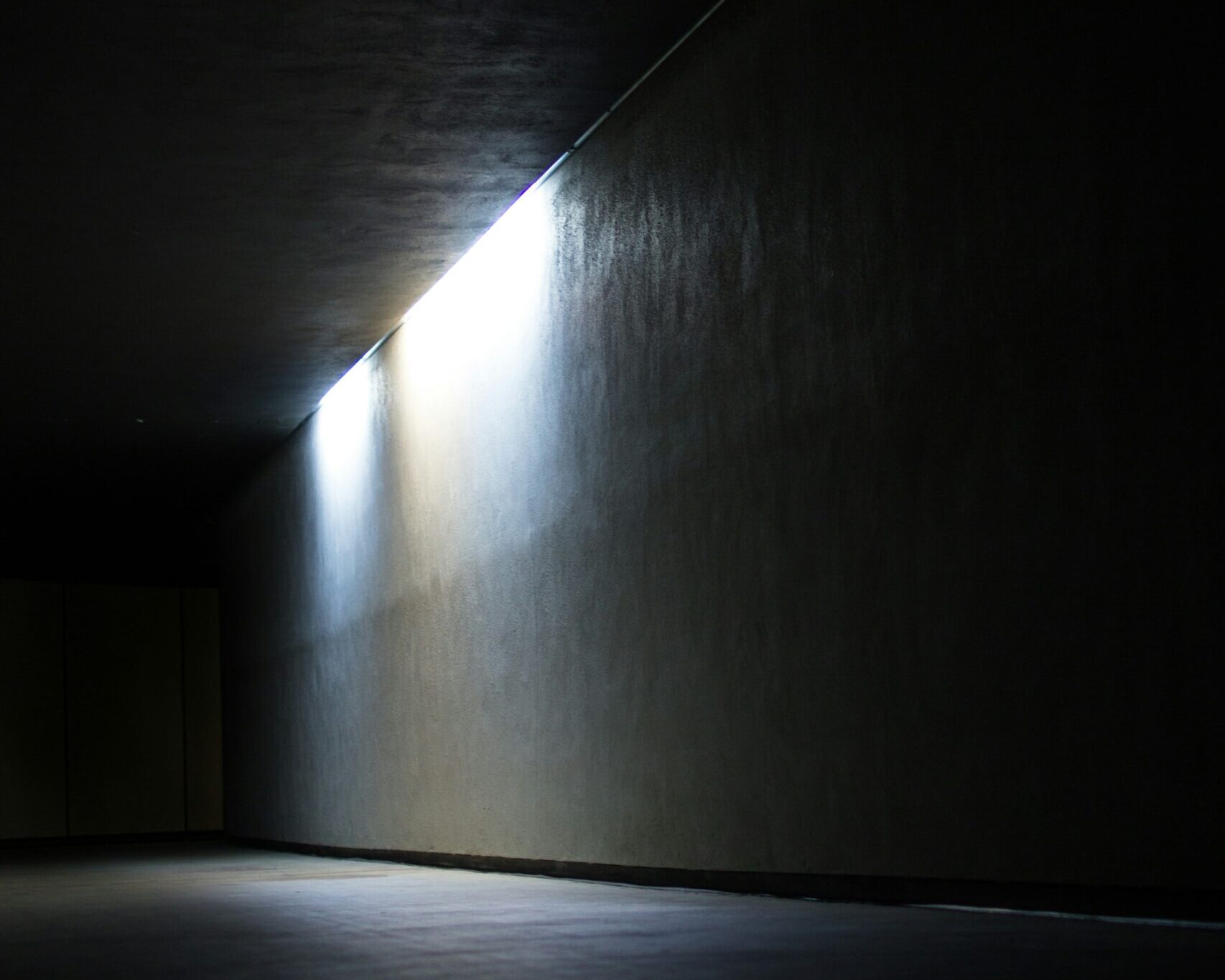 Bild von einem dunklen Raum bei dem eine Wand durch Akzentlicht hervorgehoben wird