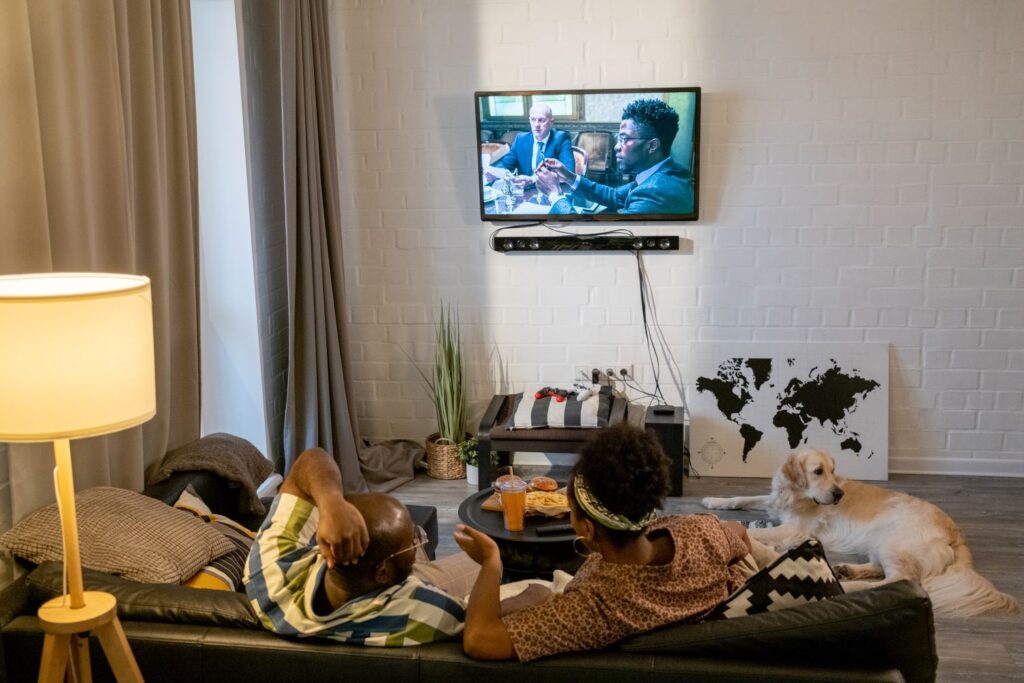 Ein Paar schaut einen TV Movie vor dem Fernseher.