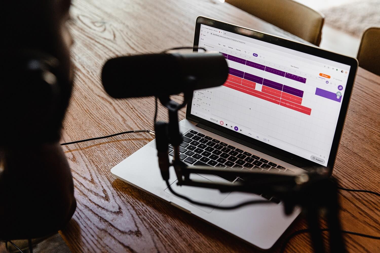 Laptop und Mikrofon kommen zum Einsatz, um den Audiokommentar für einen Screencast einzusprechen.